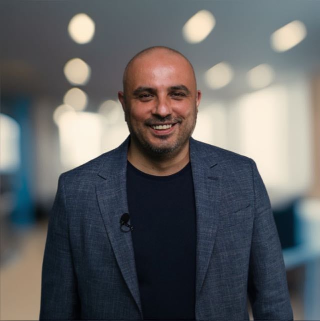 Serhat Duyar, lacivert ceketi ve siyah tişörtüyle gülümsüyor.
